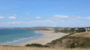 A coastal landscape with a beach, houses, and a clear sky. - Charming country home (Plogonnec)
