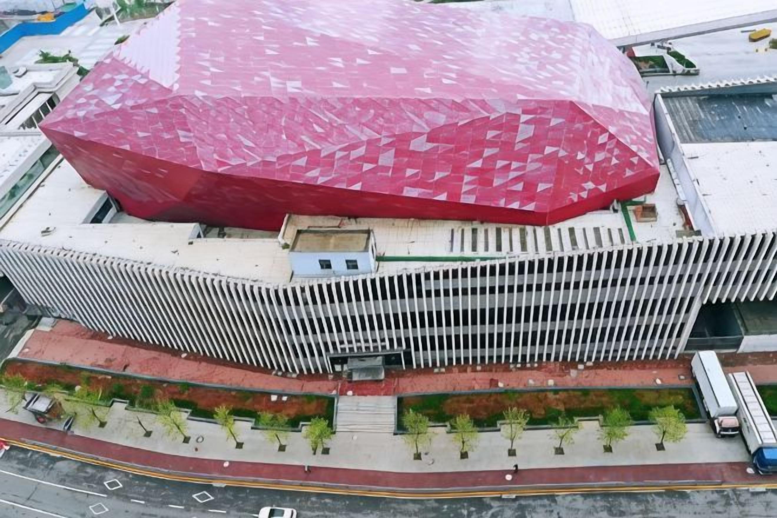 Un edificio moderno con un techo rojo característico y fachada blanca.