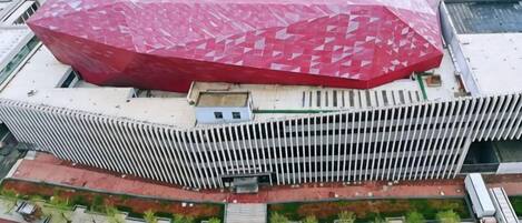 Um edifício moderno com um telhado vermelho característico e fachada branca.