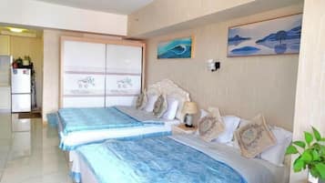 A hotel room with two beds, a large window, and artwork on the walls.
