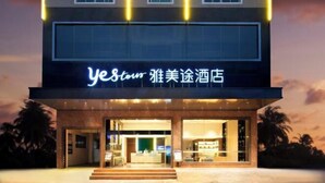 Un edificio moderno con un letrero de neón que dice "yestour" y caracteres chinos.