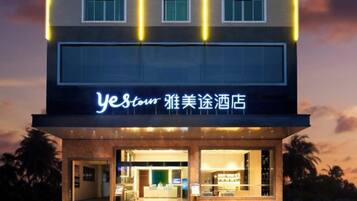 A hotel with a modern facade, illuminated signage, and a welcoming entrance.