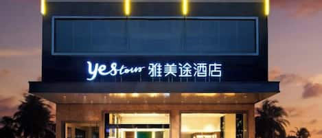 A hotel with a modern facade, illuminated signage, and a welcoming entrance.