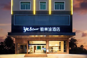 Un hotel con fachada moderna, señalización iluminada y una entrada acogedora.