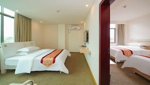 Habitación de hotel con dos camas, un televisor y una ventana con cortinas.