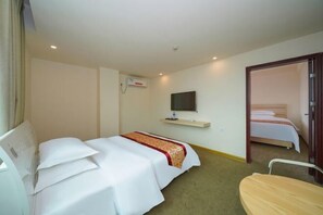 A hotel room with a bed, a TV mounted on the wall, a bedside table, and a chair. - Yestour Hotel (Guigang Pingnan Government Center Shopping Plaza) (Pingnan)