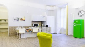 Une cuisine moderne avec des meubles blancs, un four à micro-ondes et un réfrigérateur vert.