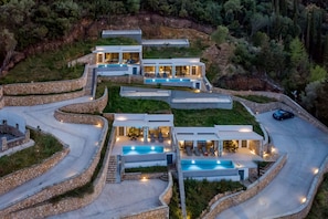 A modern, multi-story house with a swimming pool, stone retaining walls, and a winding driveway. - Modern 2 bedroom Villa Delta with Private Pool (LEFKADA)