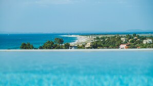 Une vue sur la côte, avec une piscine au premier plan, une plage et des bâtiments en arrière-plan.
