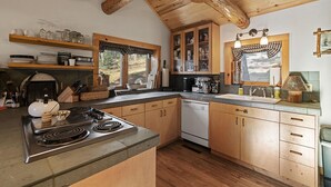 Cozinha com armários de madeira, fogão e lava-louças.