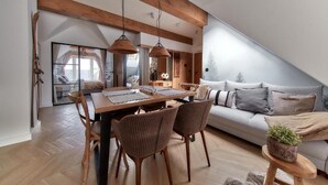 Un loft moderne comprenant un coin repas, un canapé et une petite table agrémentée d’une plante.