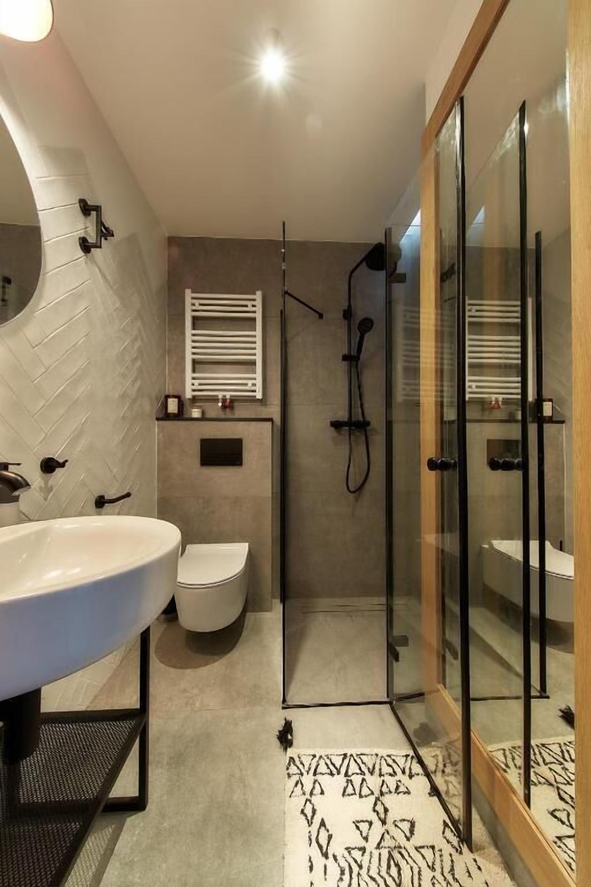 Un baño moderno con un lavamanos grande, inodoro y cabina de ducha de vidrio.