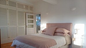 Una camera da letto con un letto grande, un armadio e un comodino con una lampada.