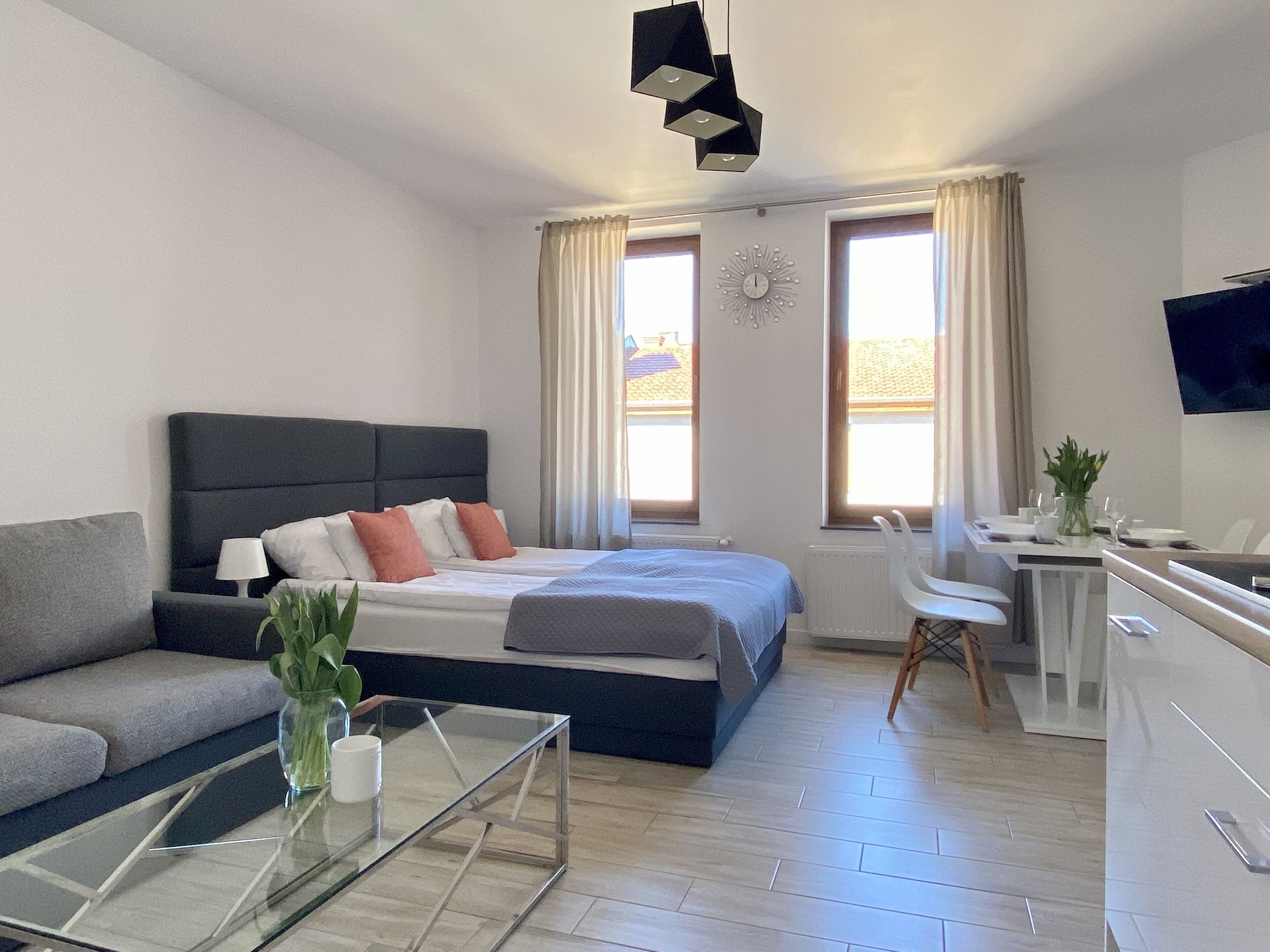 Ein modernes Hotelzimmer mit einem Bett, einer Couch, einem Schreibtisch und einem Fernseher.