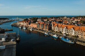 A harbor with boats docked, a bridge, and buildings along the waterfront. - Grand Baltic Apartments (Ustka)