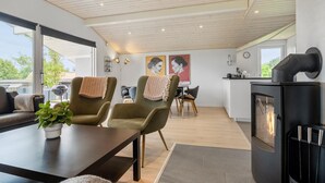 A modern living room with a dining area, a fireplace, and artwork on the walls. - 3 bedroom stunning home in Hejls (Hejls)