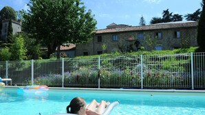 Una piscina con una persona relajándose en un flotador.