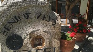 A stone sign with the inscription "ENIOE ZEY HOTEL" and a circular window. - Xenios Zeus (Aristotelis)