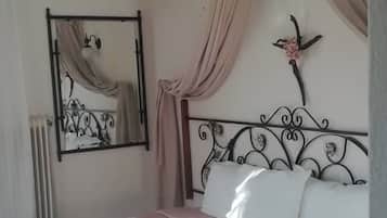 A bedroom with a bed, a mirror, an air conditioning unit, and a decorative wall piece.