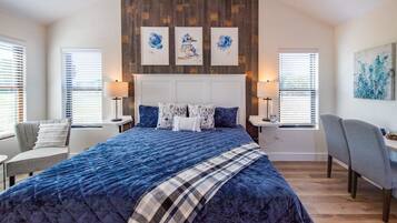 A bedroom with a large bed, a wooden headboard, and artwork on the wall.
