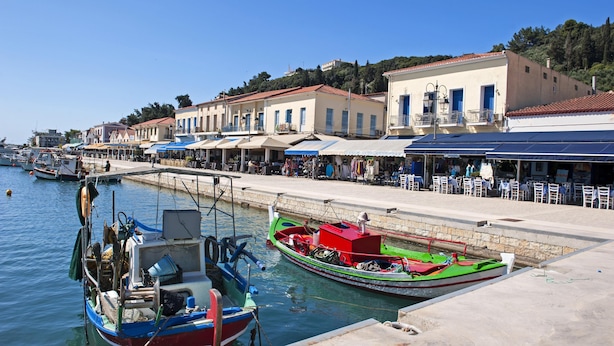 A waterfront with boats docked, a pier, and buildings with balconies. - Maritinas Stone Apartment On The Beach (Pyrgos)
