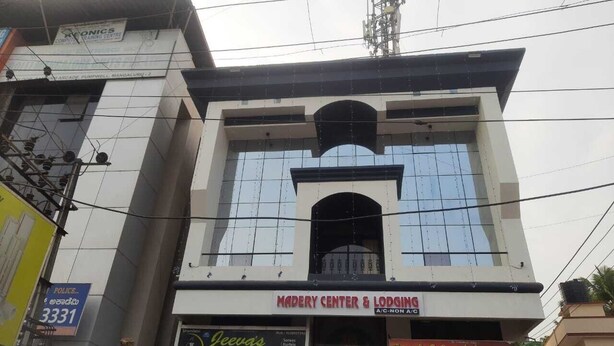 Un edificio con un letrero que dice 'MADRERY CENTER & LODGING' y 'HOTEL SHRIKRISHNA'.