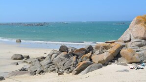 Una playa rocosa con grandes rocas y una vista despejada del mar.