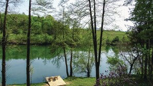 A lakeside picnic area with a wooden deck and benches. - House Kolpa Paradise Whirlpool And Sauna (Metlika)