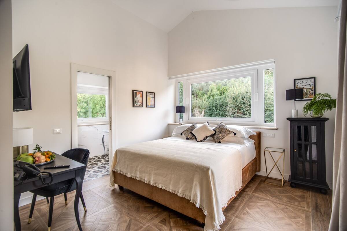 Ein Schlafzimmer mit einem Bett, einem Schreibtisch mit Stuhl, einem Fenster und einem Schrank.