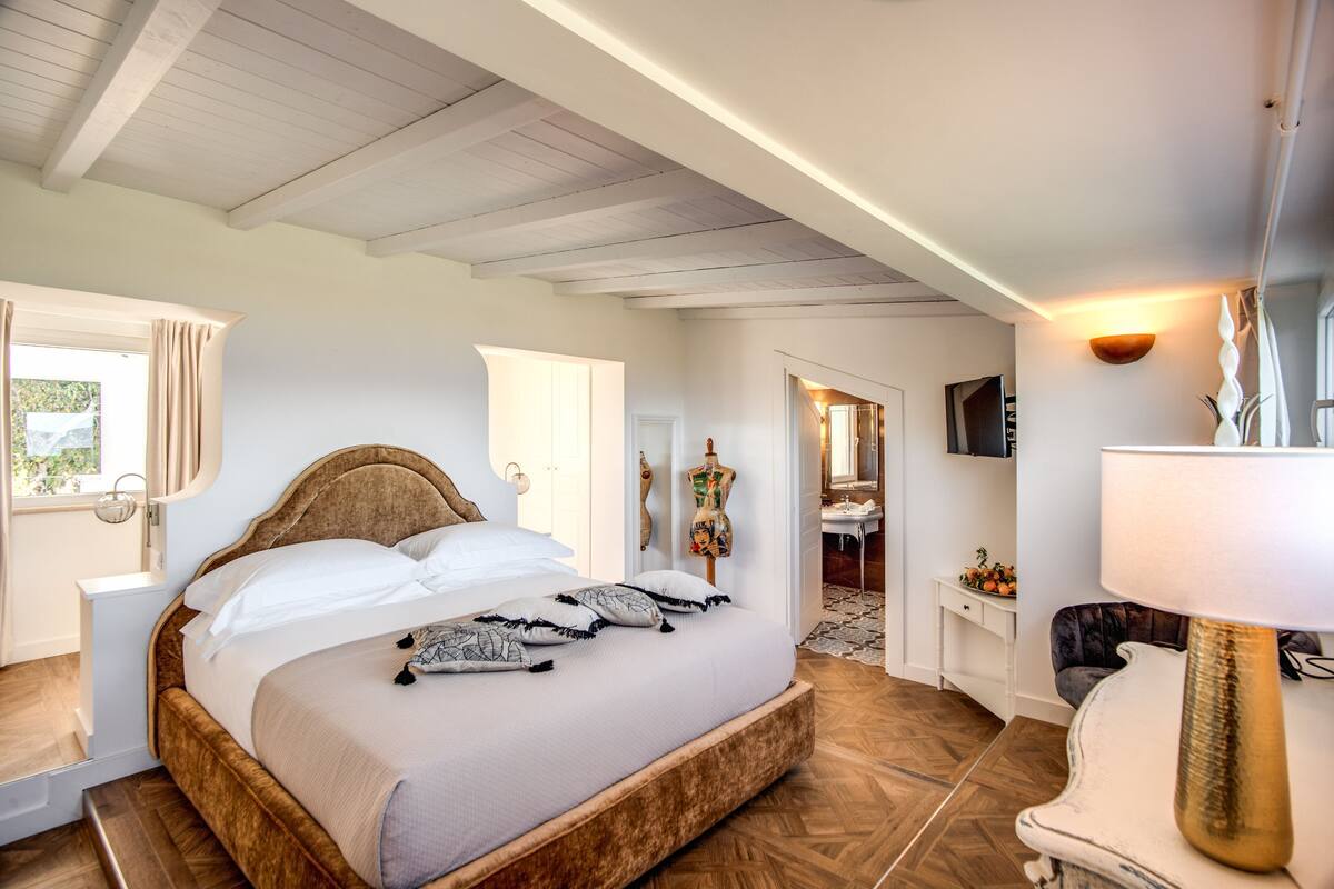 Ein Schlafzimmer mit einem großen Bett, einem Nachttisch, einer Lampe und einem Kleiderschrank.