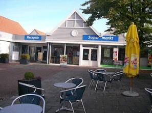 A Supermarkt with a reception area and outdoor seating with tables and chairs.