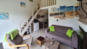 Un amplio espacio habitable con una escalera, una zona de comedor y una cocina.