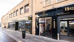Un immeuble abritant un restaurant McDonald's et un hôtel de luxe appelé « Manhattan ».