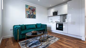 Una sala moderna con un sofá azul aguamarina, una mesita de centro y un cuadro en la pared.