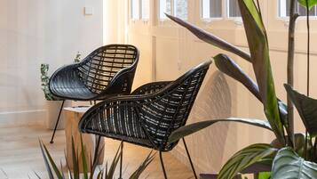 Ein Zimmer mit großen Fenstern, zwei schwarzen Webstühlen und verschiedenen Zimmerpflanzen.