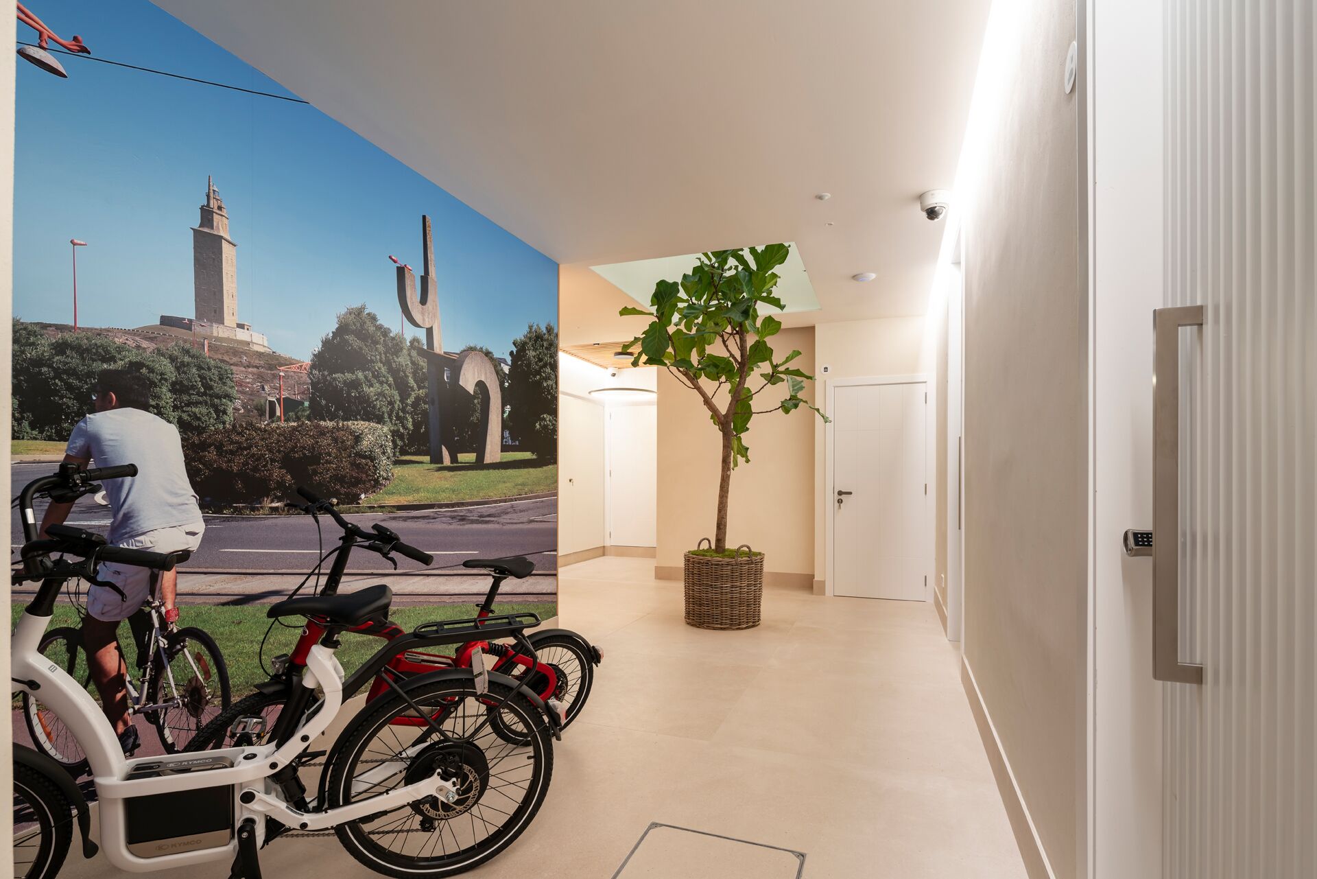 A hallway with a mural of a monument, a bicycle, and a potted plant.