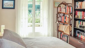 A bedroom with a bed, a bookshelf, and a window with curtains. - Beautiful home in Espeluche (Espeluche)