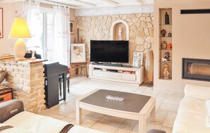 Cozy living room with a fireplace, flat-screen TV, and comfortable seating area.