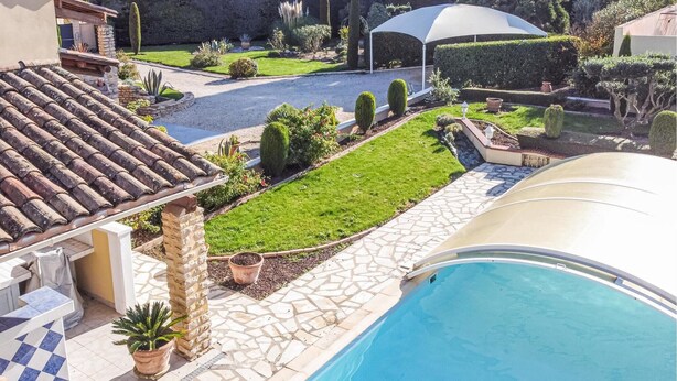 A swimming pool with a tiled deck, a stone pathway, and a well-maintained lawn with various plants. - Beautiful home in Espeluche (Espeluche)