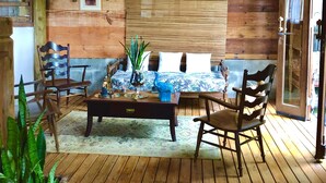 A wooden-floored room with a bed, chairs, a table, and a potted plant. - Eliza Bungalow, luxury with sea view in Trancoso (Trancoso)