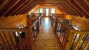 A wooden staircase in a loft-style room with a high ceiling and wooden beams. - Lake Eufaula Log Cabin, Private Dock, Premier Hunting (Georgetown)