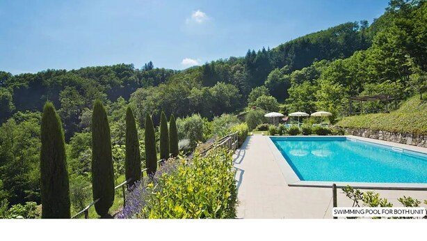 A swimming pool with a view of a lush green landscape and hills in the background. - Design house in Tuscan style surrounded by nature (Pescaglia)