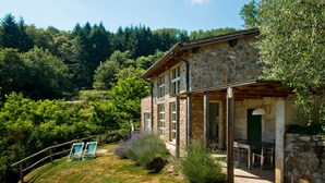 A stone house with a patio, surrounded by lush greenery and hills. - Design house in Tuscan style surrounded by nature (Pescaglia)