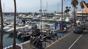 A marina with boats docked, a parking area, and a few people. - 2 Bed Hotel Apt, Sleeps 4/6, Costa Adeje, 5 minutes walk to Beach, Shops & Bars (Costa Adeje)