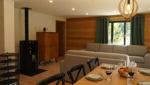 Un comedor con una mesa de madera dispuesta para dos personas, un sofá y un aparador de madera.