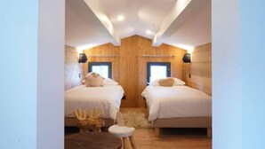 Una habitación acogedora con dos camas, una mesita pequeña y una figurita decorativa de un animal.