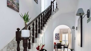 A hallway with a marble staircase, a dining area, and a view to the outside. - 22 - Unique Four Bedroom Townhouse by PMI Malta (Tas-Sliema)