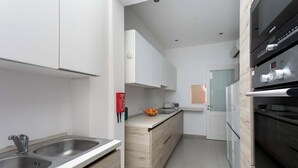 A modern kitchen with stainless steel appliances, a wooden countertop, and a white backsplash. - 22 - Unique Four Bedroom Townhouse by PMI Malta (Tas-Sliema)