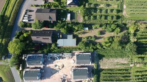 Ett flygbildsbild av ett bostadsområde med flera hus, en parkeringsplats och en åker.