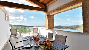 Uma sala de jantar com mesa posta para o café da manhã, com vista para uma paisagem deslumbrante.